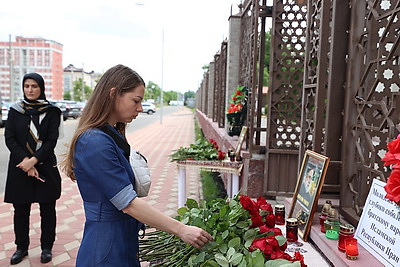 Цветы в знак скорби и соболезнований в связи с трагедией в Иране несут к посольству в Минске