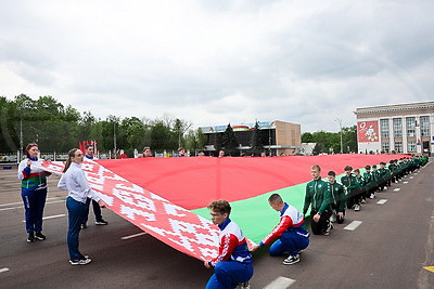 С огромной гордостью за достижения страны. Государственный флаг в 81 м пронесли по главной площади Гомеля