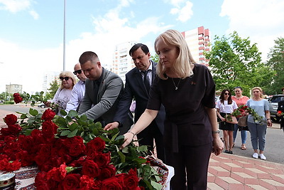 Цветы в знак скорби и соболезнований в связи с трагедией в Иране несут к посольству в Минске